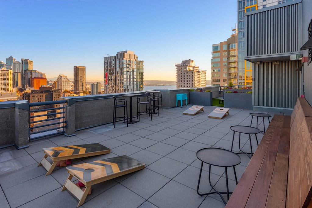a rooftop bar with a view of the city and the ocean