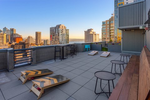 a rooftop bar with a view of the city and the ocean