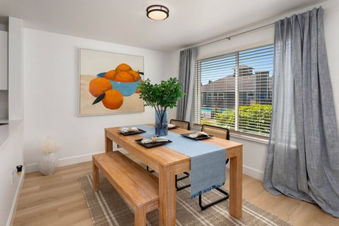 a dining room with a table and chairs and a large window