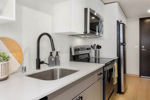 a kitchen with a sink and a stove and a microwave