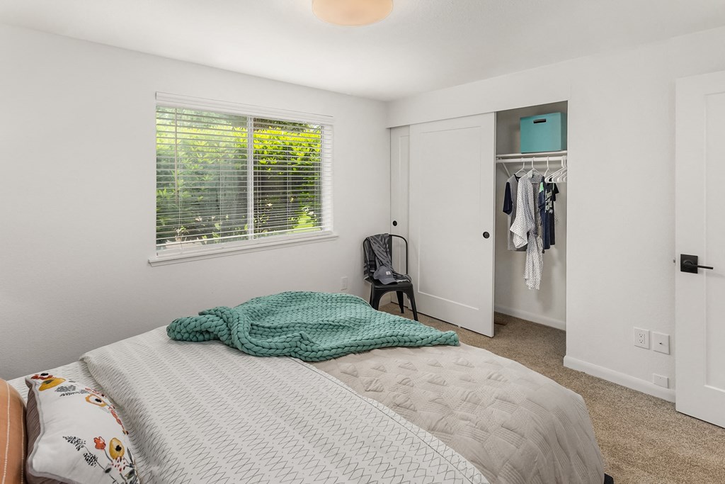 a bedroom with a bed and a closet with a window