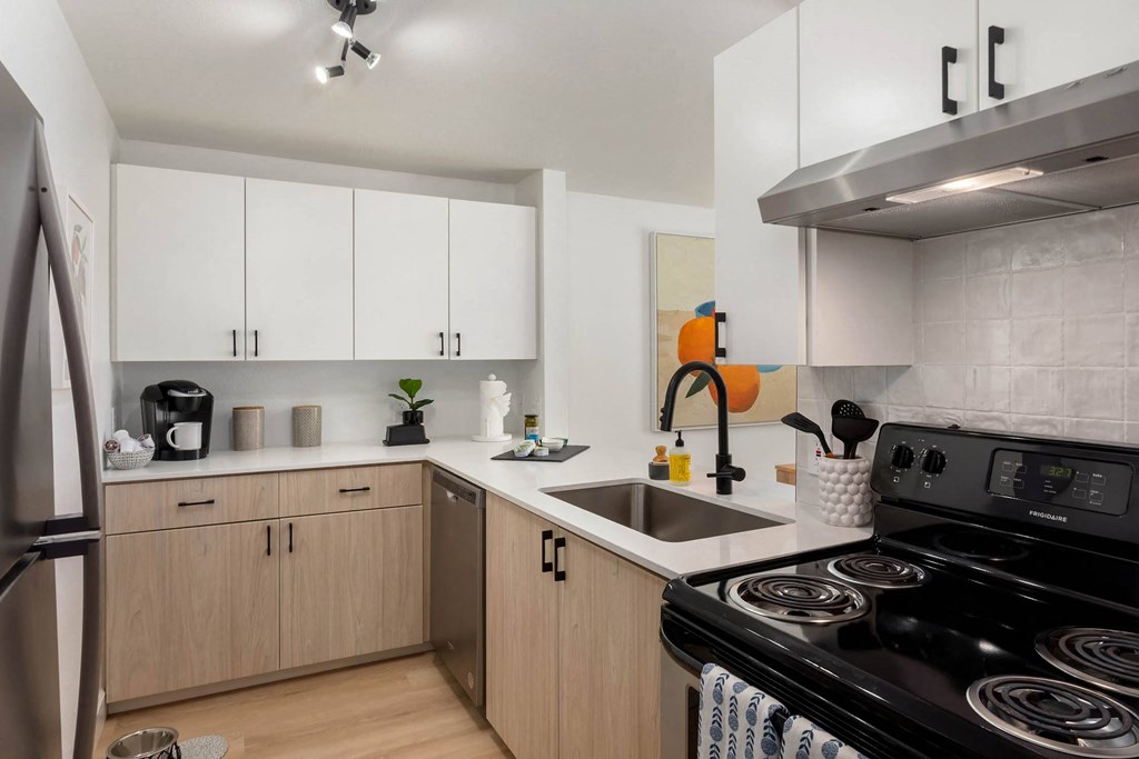 a kitchen with white cabinets and black appliances