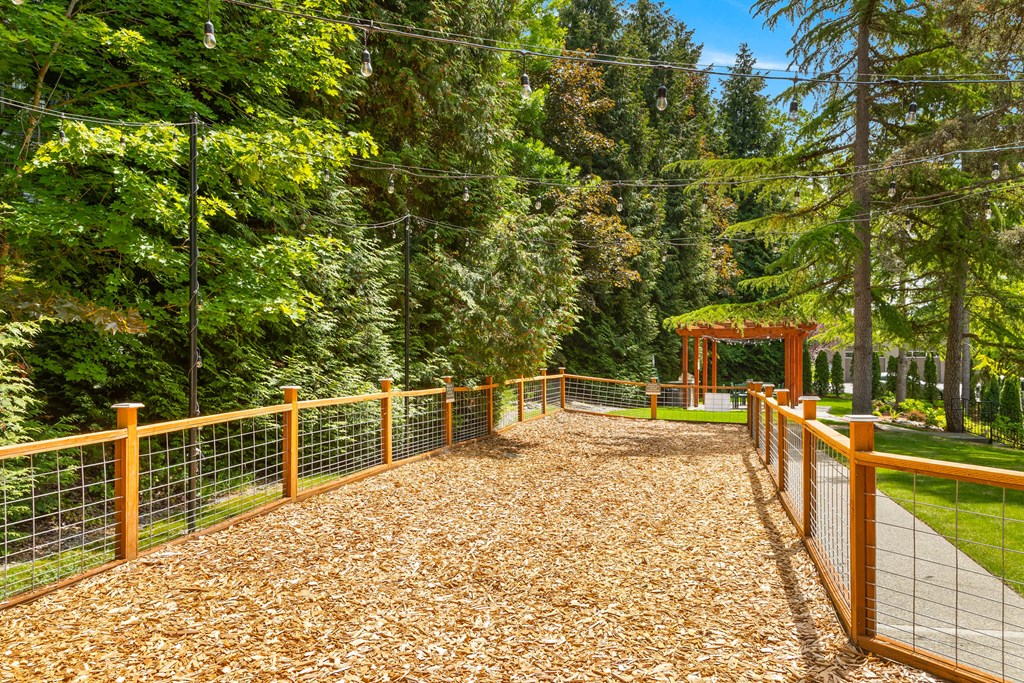 a fenced in area with trees in the background