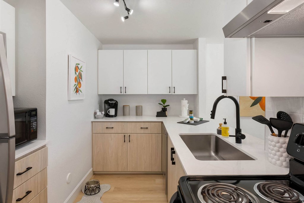 a kitchen with white walls and wooden cabinetry