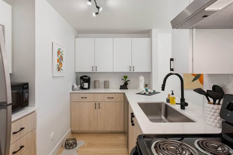 a kitchen with white walls and wooden cabinetry