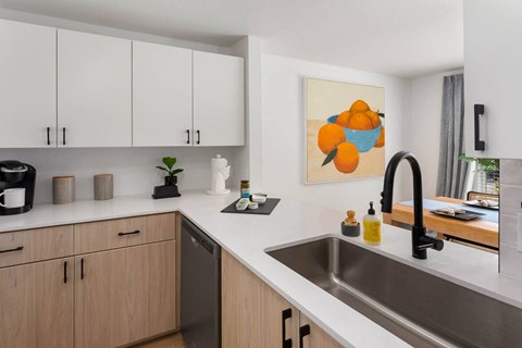 a kitchen with white countertops and wooden cabinets