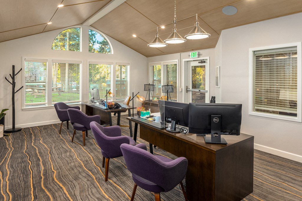an office with purple chairs and a desk with a computer