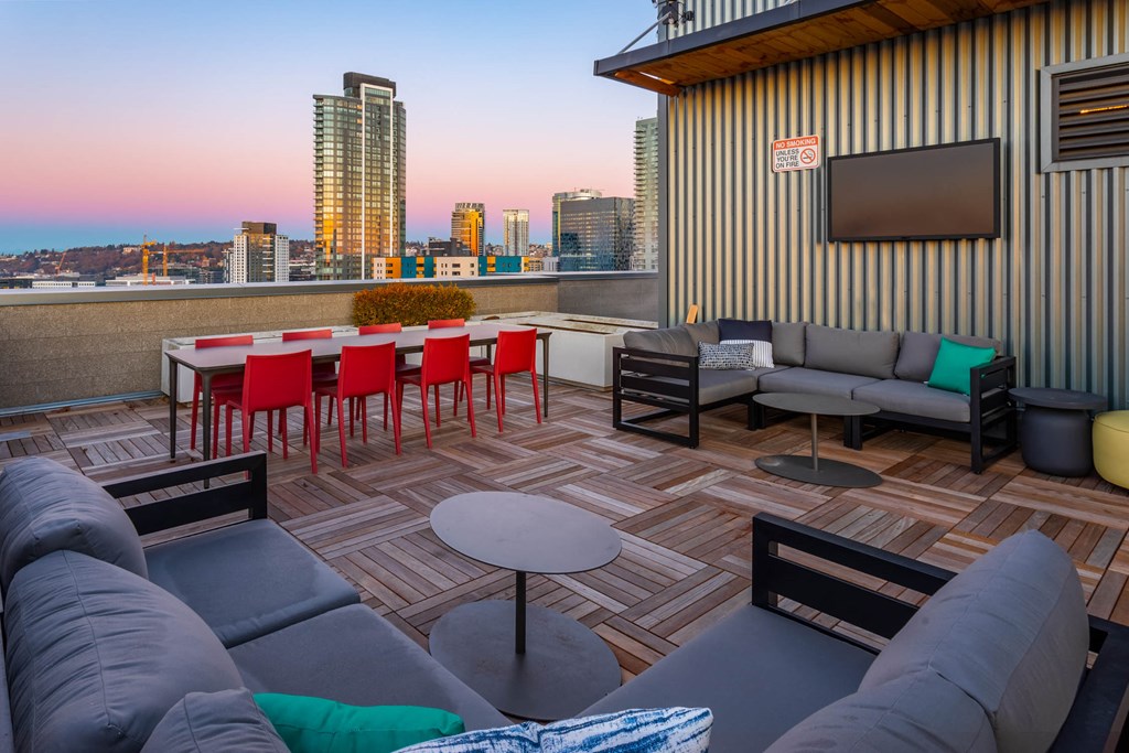 a seating area with a table and chairs on a balcony