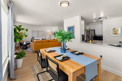 a dining room with a table and chairs and a living room in the background