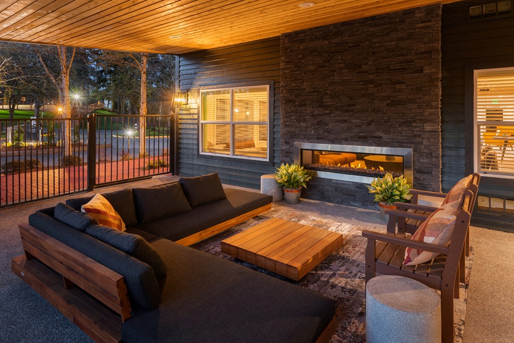 the outdoor living area has a fireplace and a couch and chairs