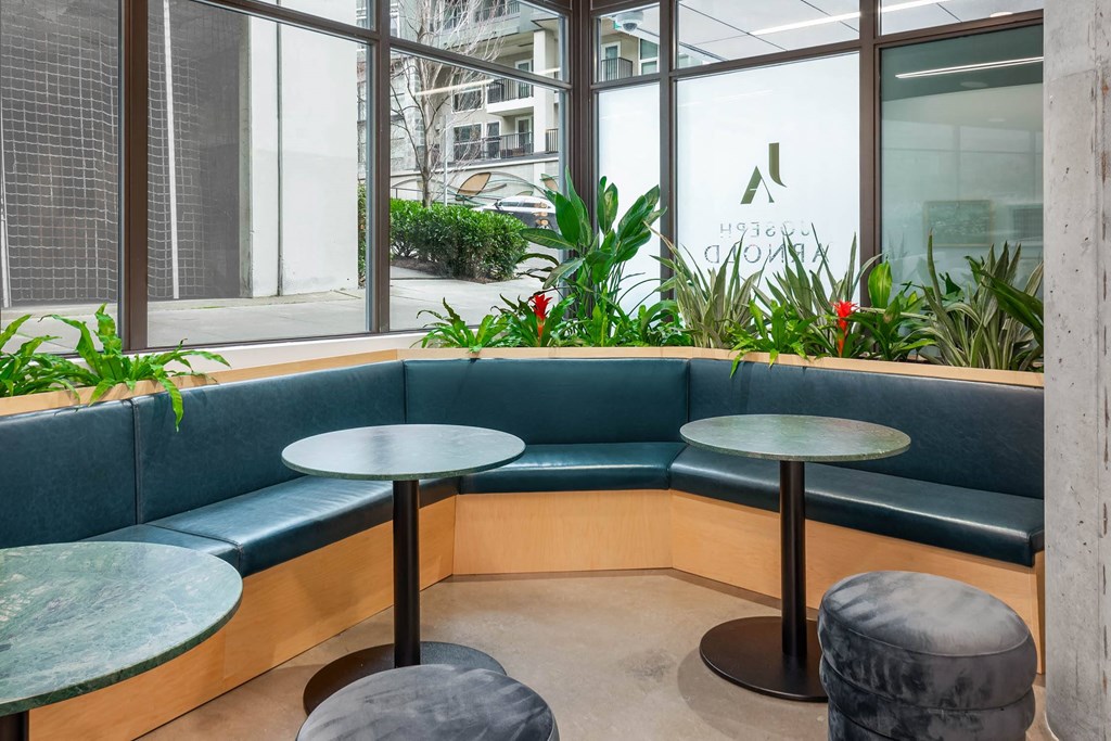 a seating area with blue couches and tables in a lobby