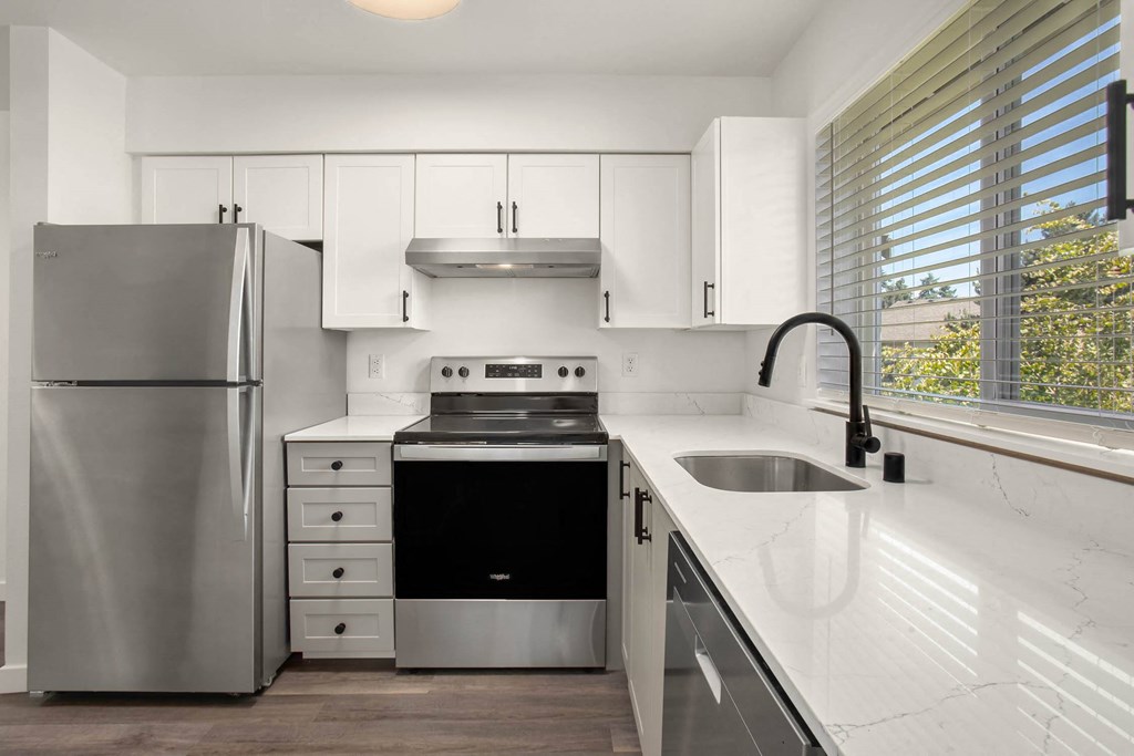 a kitchen with white cabinets and stainless steel appliances
