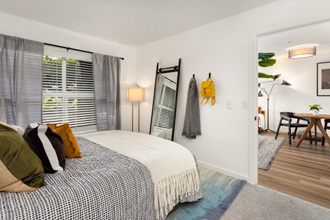 a bedroom with a bed and a mirror on the wall