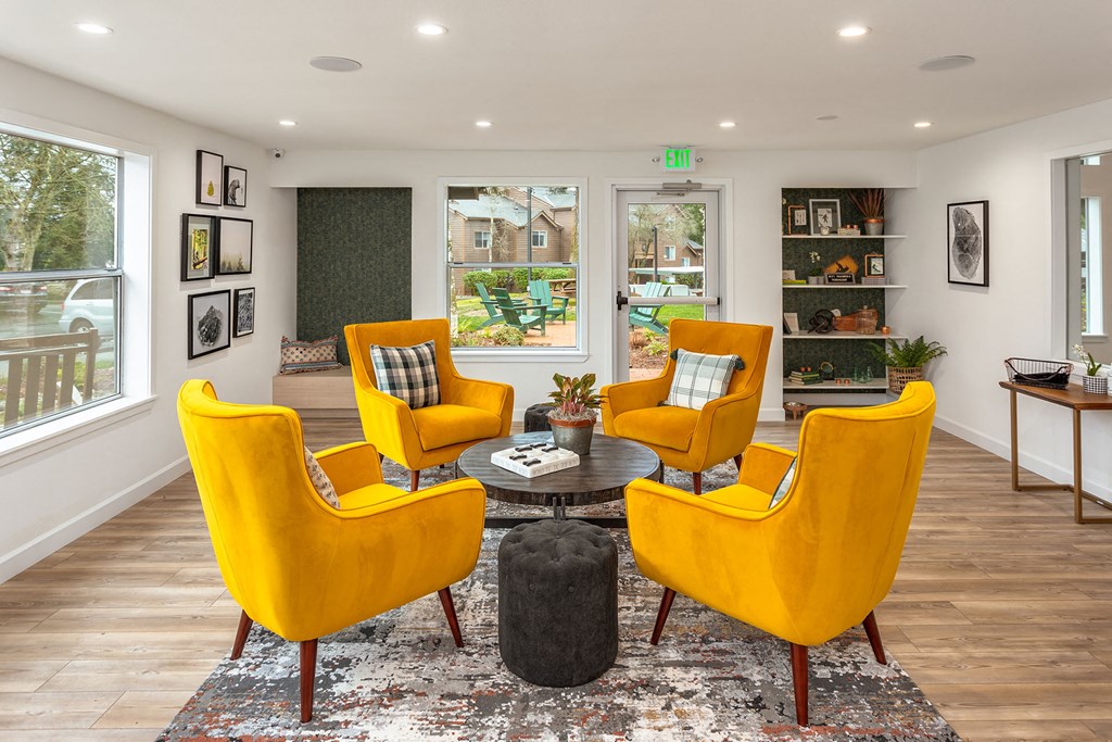 a living room with yellow chairs and a table