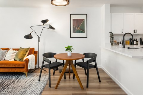 a living room with a table and chairs and a kitchen