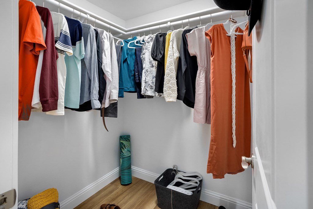 a row of clothes hanging on a rack in a closet