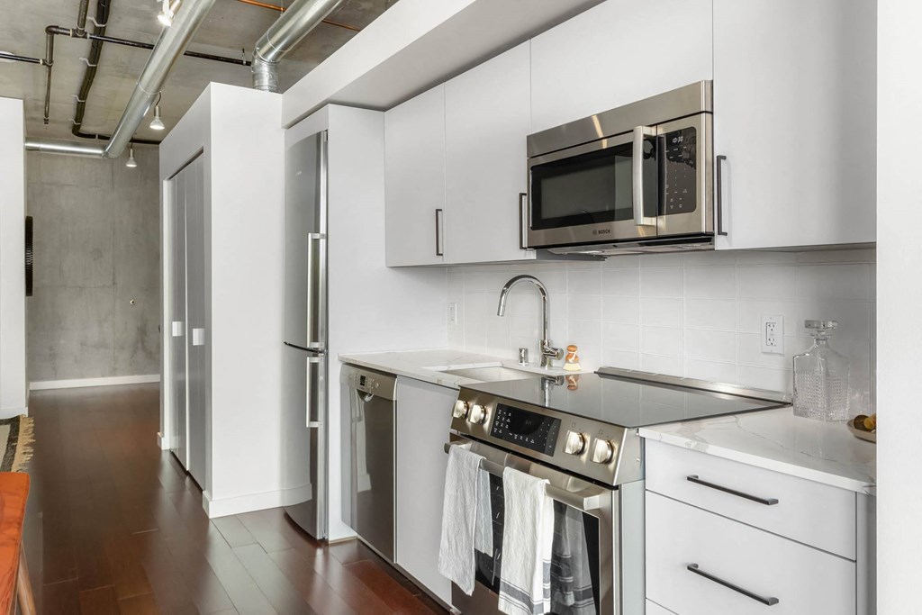a kitchen with stainless steel appliances and white cabinets