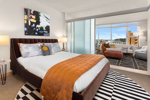 a bedroom with a bed and a view of a living room