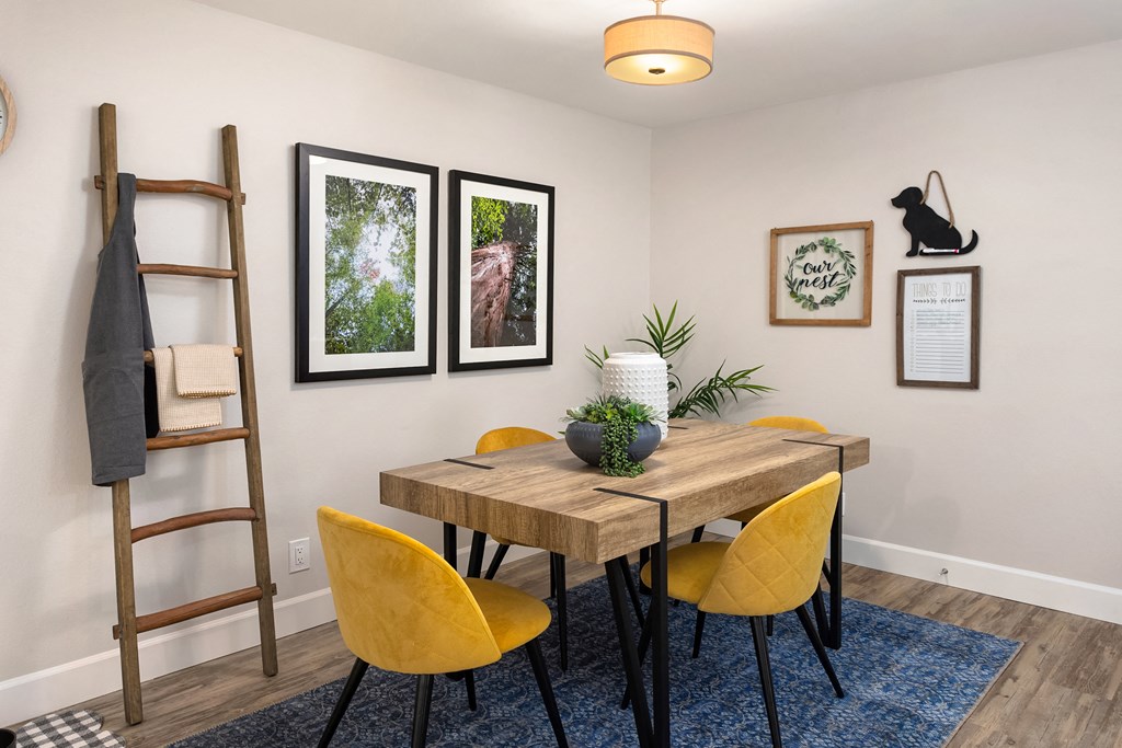 a dining room with a wooden table and yellow chairs