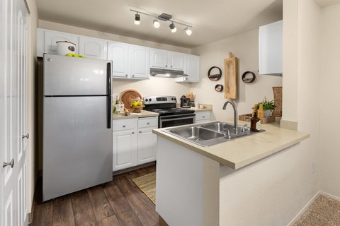 a kitchen with stainless steel appliances and white cabinets