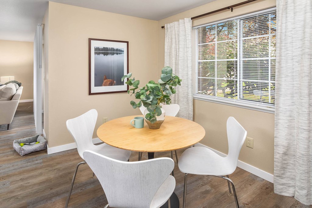 a dining room with a table and chairs and a window