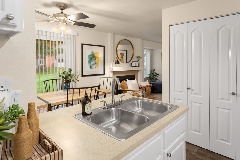 an open kitchen and living room with a stainless steel sink