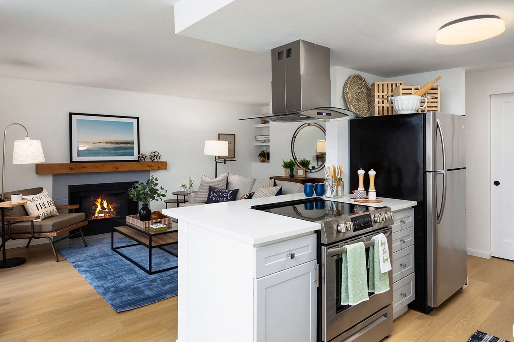 a living room with a kitchen and a fireplace