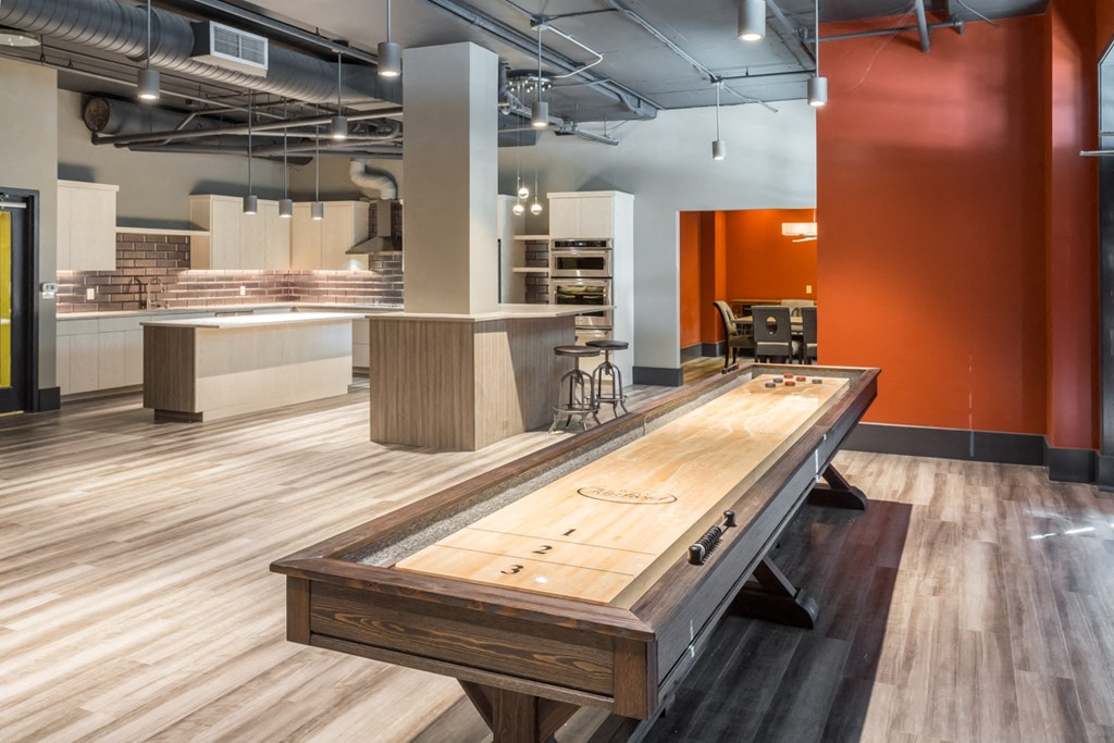 a shuffleboard table in a room with a kitchen