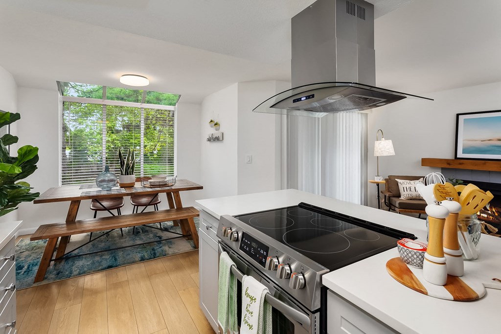 a kitchen with a stove and a sink and a dining table