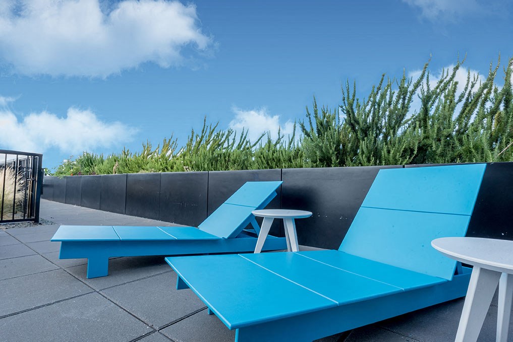 a seating area with a blue bench and a table