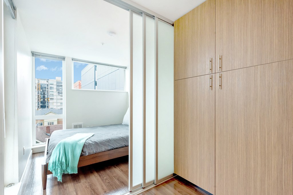 a bedroom with a bed and wooden cabinets