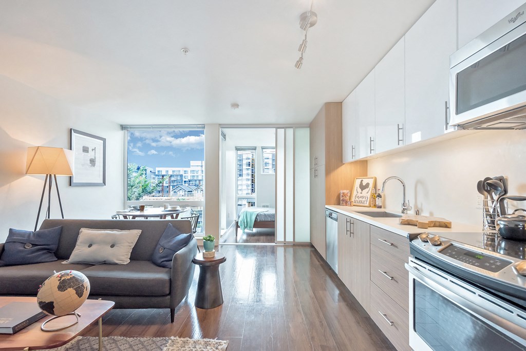 a living room with a couch and a table and a kitchen