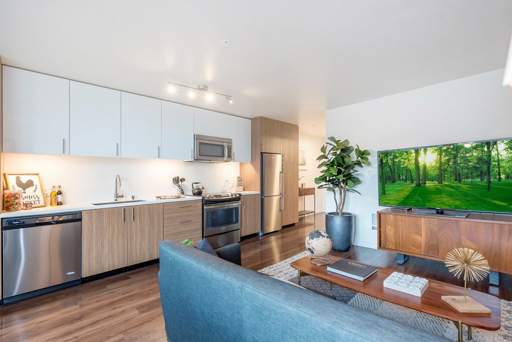 a kitchen and living room with a large tv