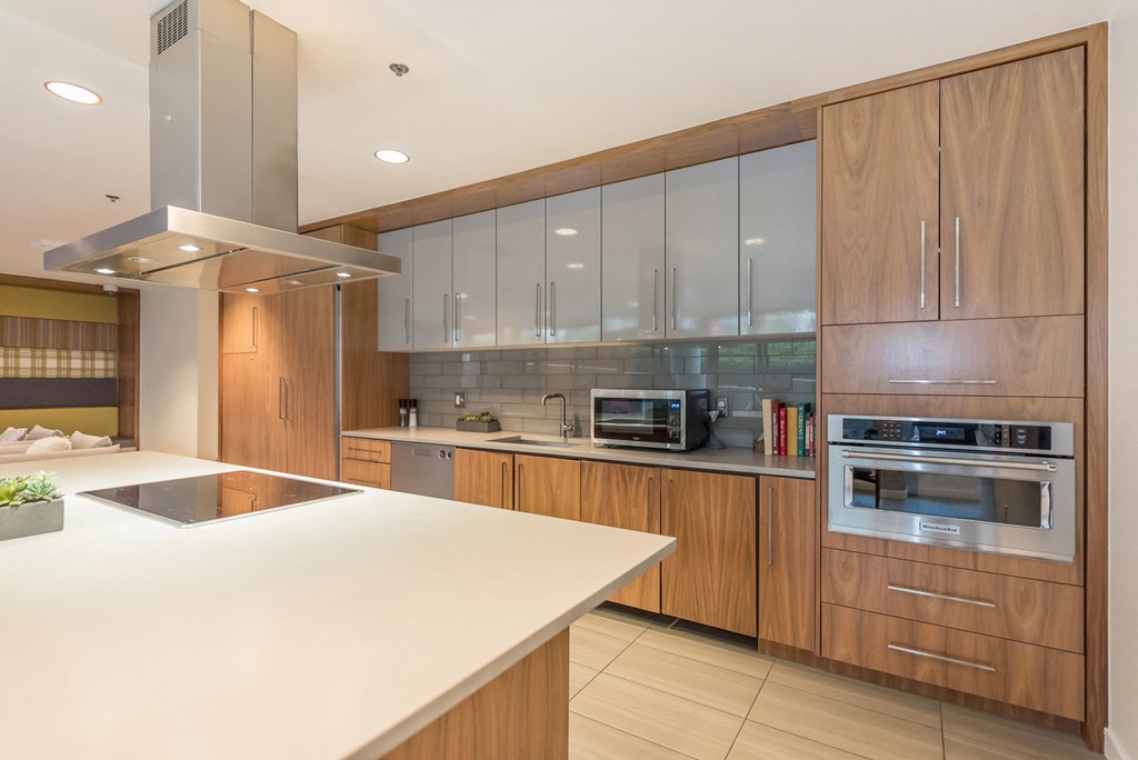 a modern kitchen with wooden cabinets and a white counter top