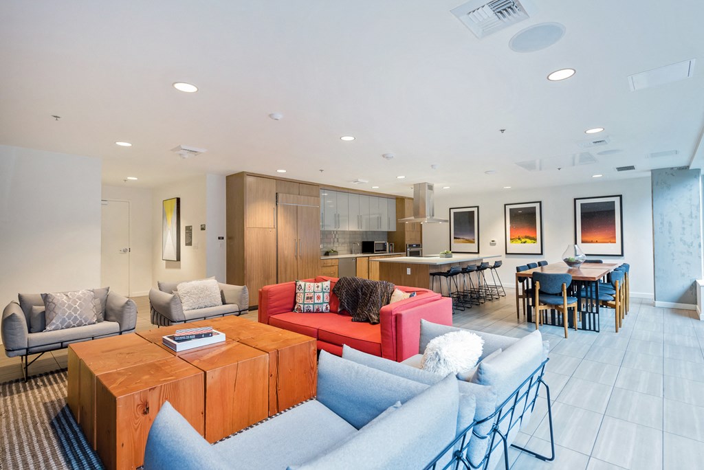 a living room with couches and chairs and a kitchen