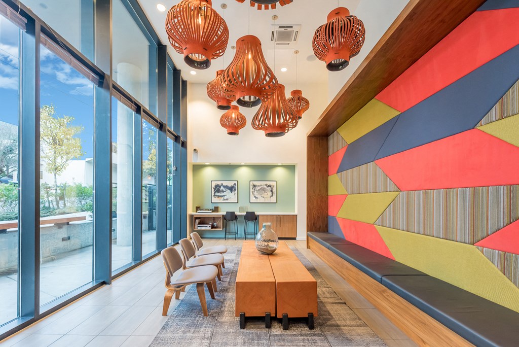 the lobby of a condo with large glass windows and a colorful wall