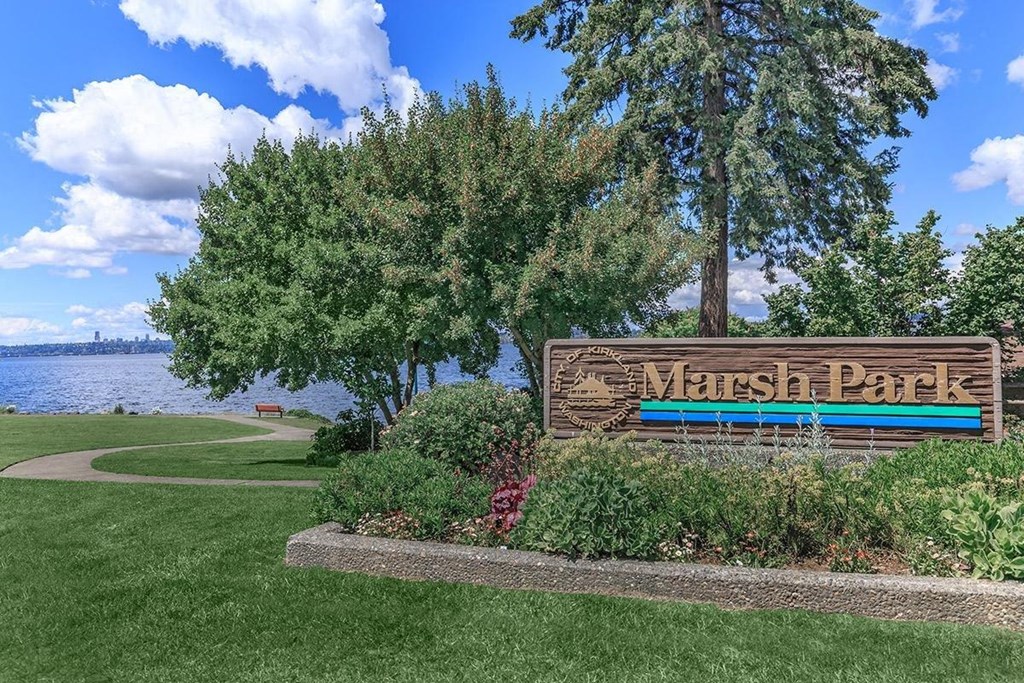 a park sign with a lake in the background