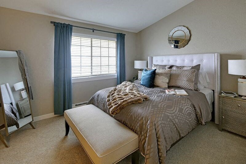 a bedroom with a bed and a mirror on the wall