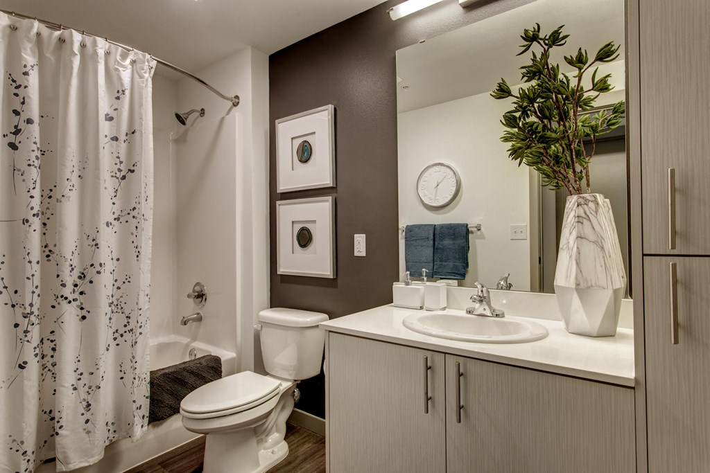 a bathroom with a shower and a sink and a toilet