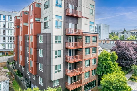 A tall apartment building with balconies and multiple windows.