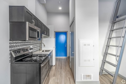 A modern kitchen with a blue door in the background.