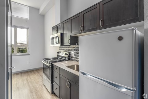 A modern kitchen with a white refrigerator, stove, and oven.