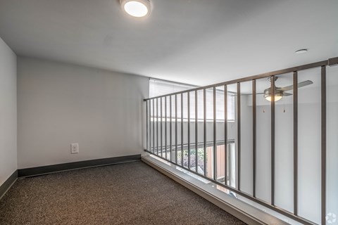 A room with a carpeted floor and a metal railing.