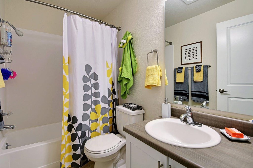 a bathroom with a shower curtain and a toilet and a sink