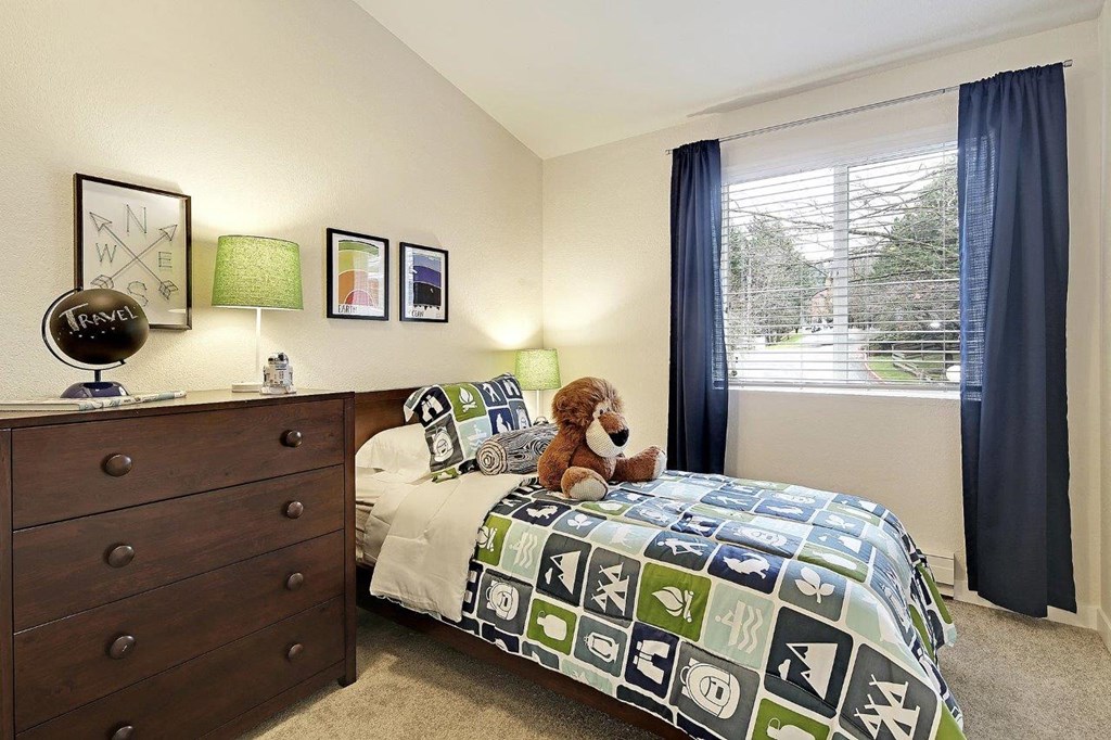 a bedroom with a bed with a teddy bear on it