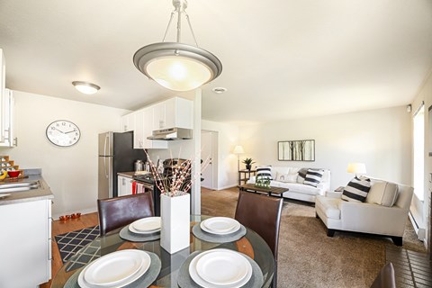 A modern dining room with a glass table and chairs.