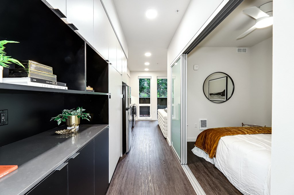 a bedroom with a bed and a black wall and a door to a bathroom