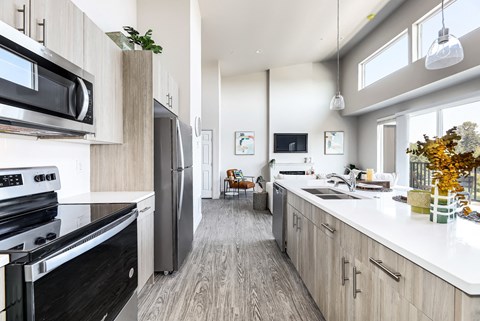 a kitchen with white counter tops and black appliances