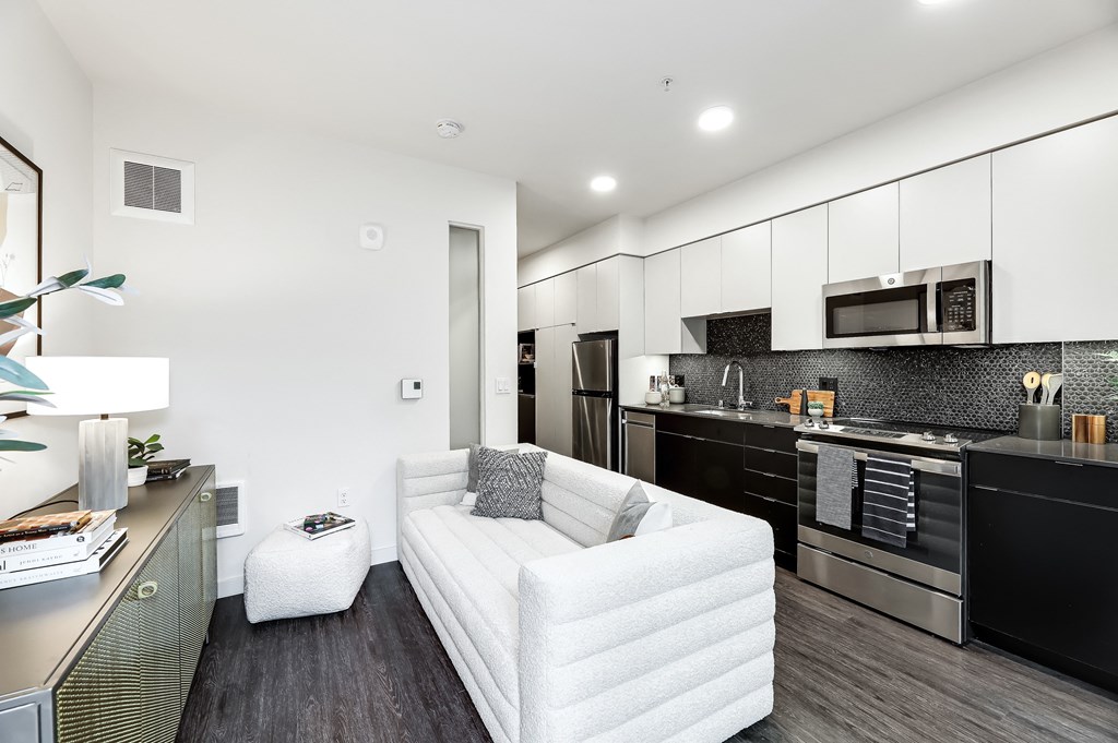 a living room with a white couch and a kitchen