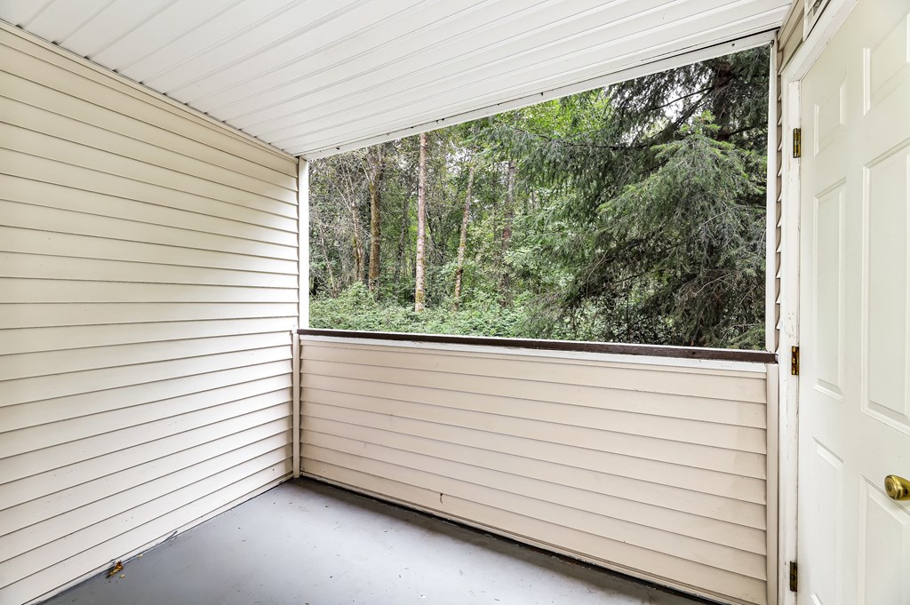 a room with a large window overlooking a forest